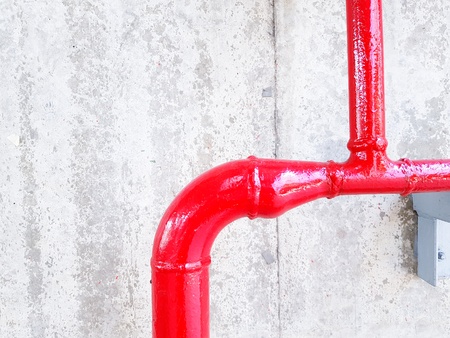 Close up red gas, oil and water pipeline on the white concrete wall with copy space - Industrial and Construction conceptの写真素材