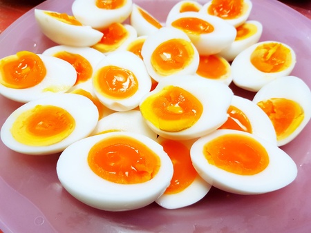 Many boiled duck eggs sliced on the pink plastic plate - Diet and Healthy foodの写真素材