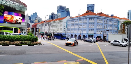 Singapore, Singapore - June 29, 2018: The people waiting for cars stop to cross the street in the...