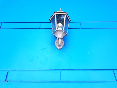 Vintage gray lamp installed on blue wall background - Object, Decoration and Interior design concept
