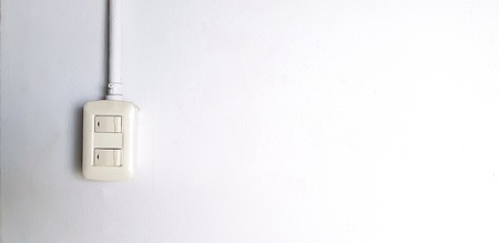 Two button of light switch and white pipe line installed on white concrete wall with copy space - Electricity and Electrical equipment conceptの写真素材