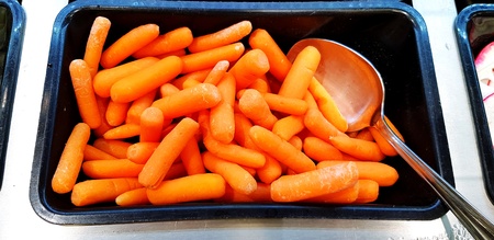 Many fresh small carrot contain in black plastic box with stainless steel spoon for sale - Fruit, Salad and Organic food conceptの写真素材