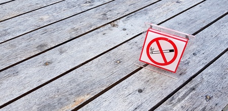 Sign or symbol non smoking area plate putting on rough wooden table with copy space - Restrict area, Law, Rule, Air freshness and Pollution conceptの写真素材