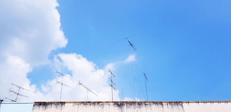 Many television antenna on rooftop of building with white cloud and blue sky with copy space - Technology and Art conceptの写真素材