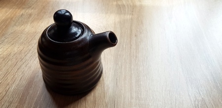 Black ceramic jug or mug tea putting on the wooden table with copy space -  Single object, Design and Container conceptの写真素材