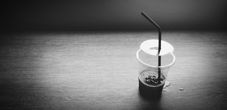 Plastic glass of iced coffee or water putting on wooden table in black and white style with copy space - Refreshment, Drinking, Art and Background conceptの写真素材