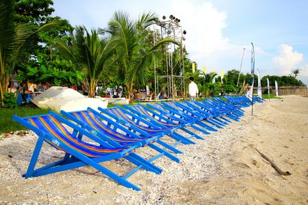 Bangkok, Thailand - May 19, 2018: Many blue beach chair on for customer or people sitting to take a rest on vacation day with palm or coconut tree and blue sky background - Travel place and Relaxingのeditorial素材