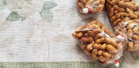 Roasted peanuts in plastic bag for sale on old cotton at local street food market with left copy space - Food and Snack conceptの写真素材