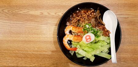Top view or flat lay of Kaisen ramen Noodle with prawn, fried squid, pork minced, Chinese mushroom,...