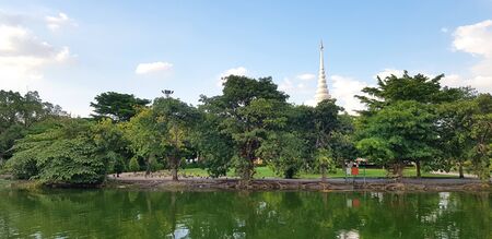 Beautiful green park with lake, tree, white pagoda, clouds and blue sky background - Beautiful in...