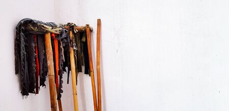 Mop for cleaning floor with wooden handle leaning or isolated on white concrete wall with right copy...