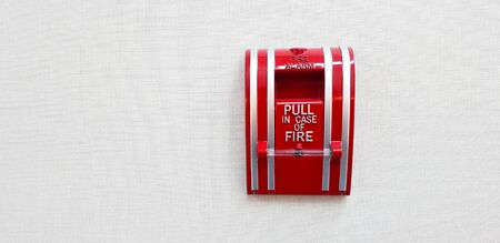 Fire alarm switch box for pull in case of fire isolated on grey or gray wall background with right copy space. Prevent emergency event conceptの写真素材