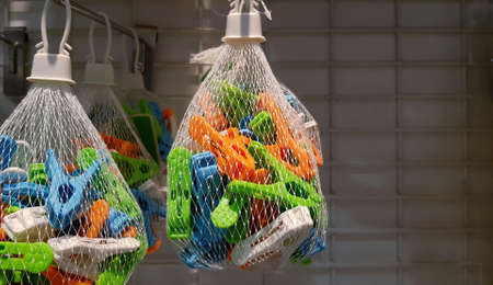 Close up colorful clothespin in net bag hanging for sale with copy space on right. Object for using...