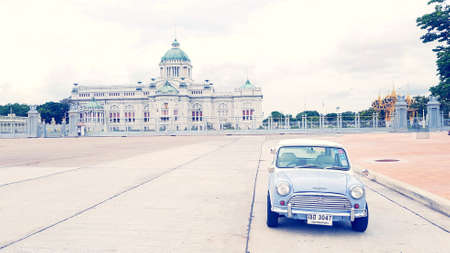 Bangkok, Thailand - June 30, 2020: Blue classic Mini Austin parked on street with ancient castle and...