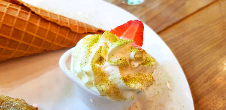 Close up sweet whipped cream with green tea powder on topping and fresh strawberry serve with baked...
