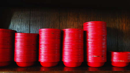 Red bowl putting or sorting on wooden shelf at Chinese restaurant. Group of object, Food Container and Dishware conceptの写真素材