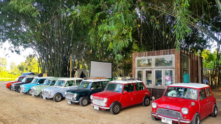 Nakhon Nayok, Thailand - December 5, 2020: Many Austin Mini cooper or classic car parked on street with bamboo forest and house or home background with copy space. Group of vintage or retro vehicle.のeditorial素材