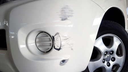 Scratches on white car after accident. Damaged on front bumper.の写真素材