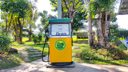 Bangkok, Thailand - December 25, 2020: Yellow and green vintage gasoline or gas station on footpath...