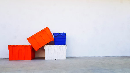 Many colorful plastic box putting and stacked on floor with white wall background and copy spaceの写真素材