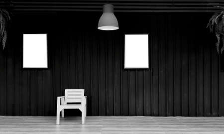 Wooden chair with two picture frame or mock up and copy space for add wording or text on black shutter background in black and white. Dark wall and hanging light and vine, creeper plant. Art designの写真素材
