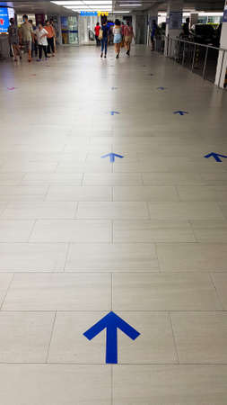 à¸ºBangkok, Thailand-February 5, 2020: Many Arrow sign on floor or ground tell and give direction go straight to entrance of department store with Asian people walking in and out to building background.のeditorial素材