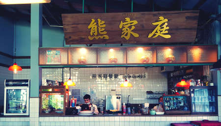 à¸ºBangkok,Thailand-April 28, 2021: Cashier counter for order food for eating food at Chinese restaurant. Exterior design bar with many cabinet, lighting hanging and people work inside in vintage tone.のeditorial素材
