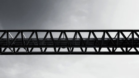 Bottom view of stainless steel electrical or communication cable tray with clear blue sky background with copy space. Iron bridge cross to air or heaven and industrial and installed system.の写真素材