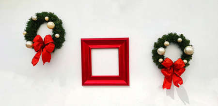 Christmas, happy new year wreath decoration with red ribbon, white ball and red picture frame for add wording isolated on white wall background. Object for decorated party, festivaの写真素材