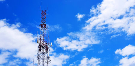 Red and white telecommunication, broadcast TV, digital television, radio, Transmission, microwave or mobile tower with blue sky and cloud background and copy space. Technology andの写真素材