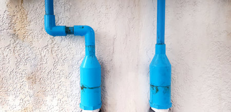 Blue water pipeline or pipe and plastic  installed with stain dirty on white concrete wall and copy space. Inspection, Dangerous install and not safety concept.の写真素材