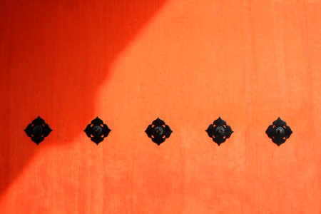 Vintage red or orange wooden door or window for background with black stainless steel symbol. Retro wood wallpaper with shadow at temple Tokyo, Japan.の写真素材