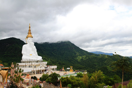 Big white monk statue with green mountain, sky and white cloud background with copy space at Thai temple Phetchabun, Thailand. Landmarks and famous place for travel. Religion and Aの写真素材