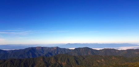 Landscape view of green mountain hill with mist and clear blue sky background with copy space on above at Doi Pha Hom Pok National Park, Chiang Mai, Thailand. Natural wallpaper andの写真素材