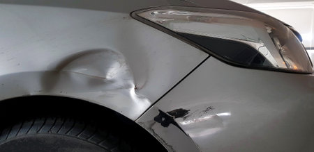 Scratches on gray, grey or bronze car after accident. Damaged on right front bumper near wheel. Insurance and injury of vehicle conceptの写真素材