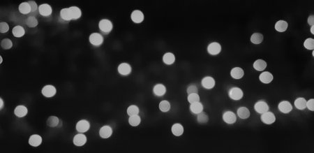 Blurred gray or grey Bokeh of light on dark or black background in monochrome style. Lighting blurry wallpaper. Festival or Celebration and Art of abstract concept.の写真素材
