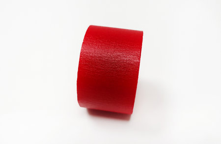 Red masking tape roll isolated on white background. Object for stick on paper.の写真素材