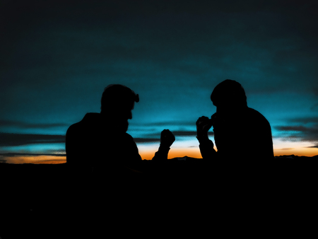 Silhouette of two fighters at sunset in mountain. Standoffの写真素材