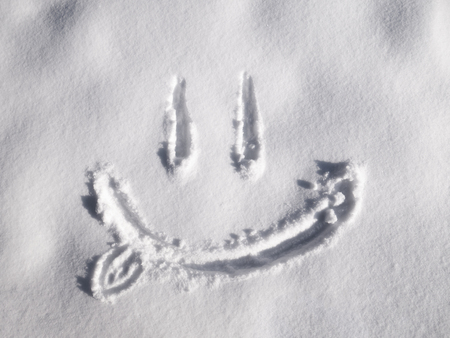 Smile emoji painted on the snow, close-upの写真素材