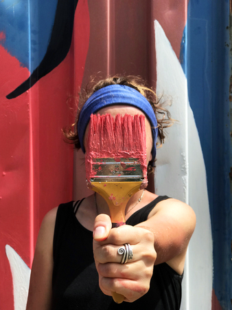 Girl paints the wall of the container. Face brushの写真素材