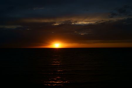 Spreaded rays of setting sun through the cloudsの写真素材