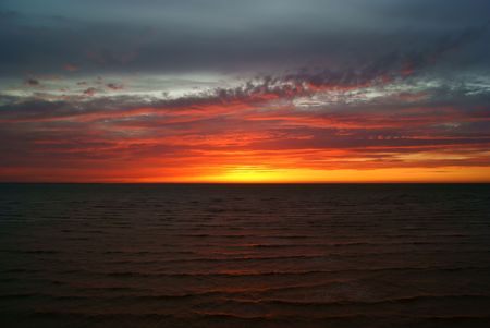 Floccus clouds in setting sun above the seaの写真素材