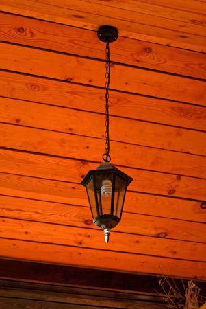 Lamp hung up by chain on wooden backgroundの写真素材