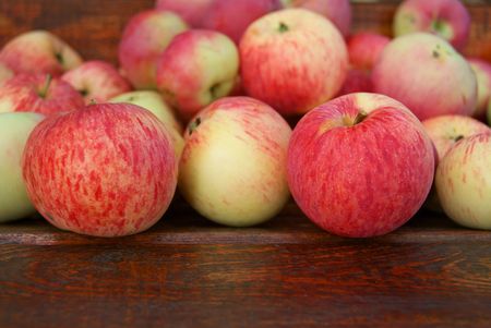 Red apples laying on wooden benchの写真素材