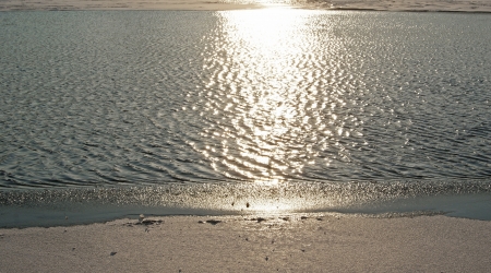 Close-up of a river with ice thawing under spring sunの写真素材