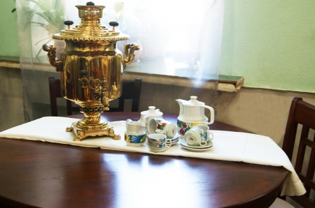 Vintage copper tea pot and tea things on the tableの写真素材