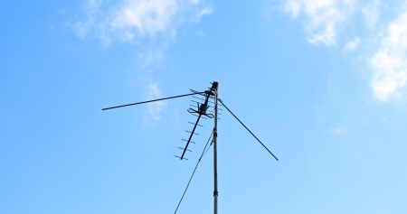 External outdoor TV antenna with amplifier in the blue skyの写真素材
