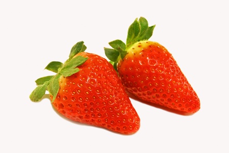 Two red strawberries closeup over white backgroundの写真素材