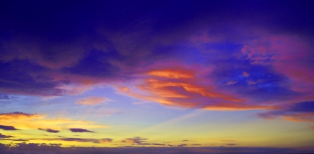 Saturated colorfull clouds with sun rays at sunsetの写真素材