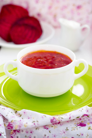 Red Ukrainian borsch soup with sour cream in a white plate.の写真素材